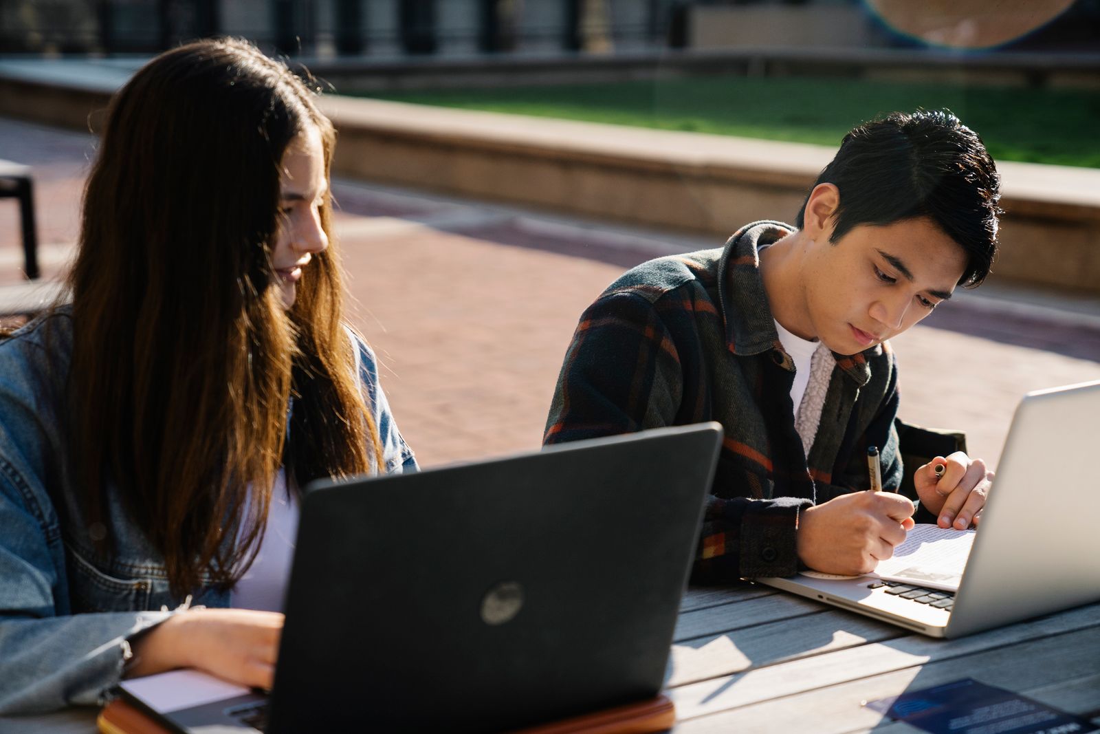 A student and facilitator reviewing coursework together, AI tutor open alongside